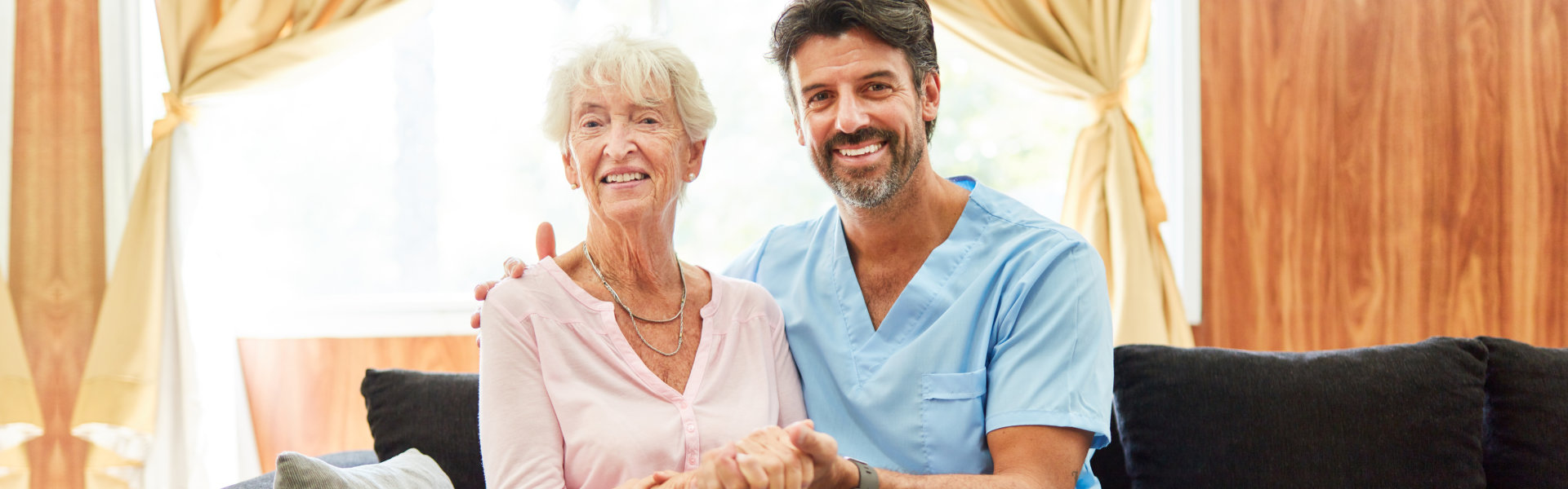 nurse and elderly woman sitting and looking at the camera