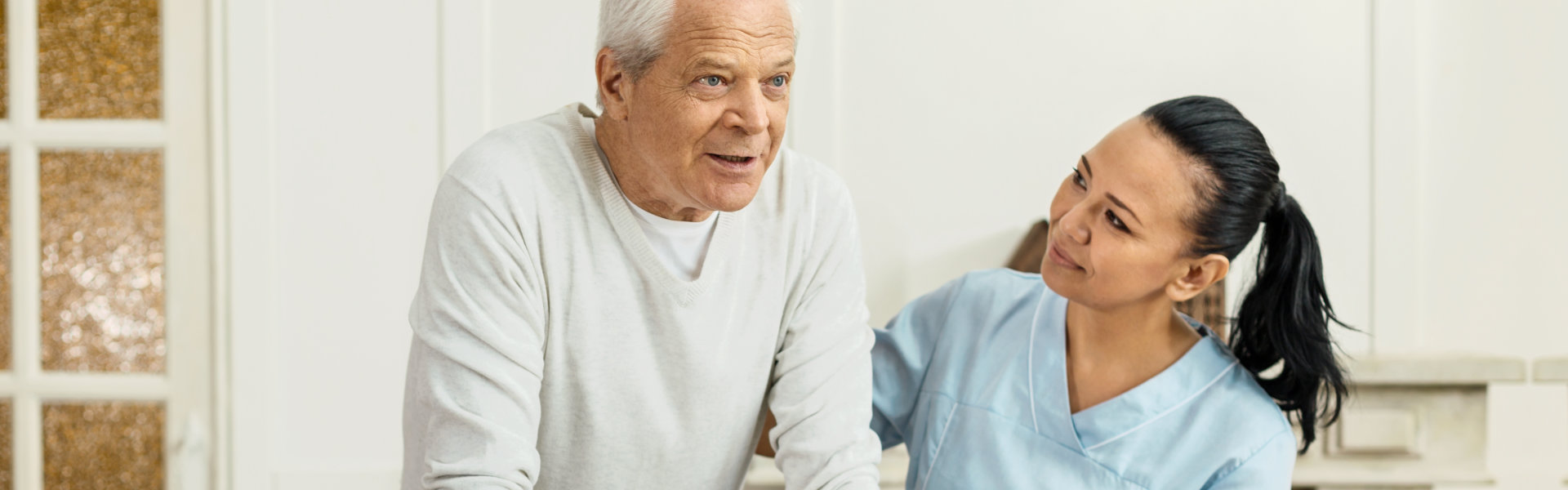 nurse assisting elderly man